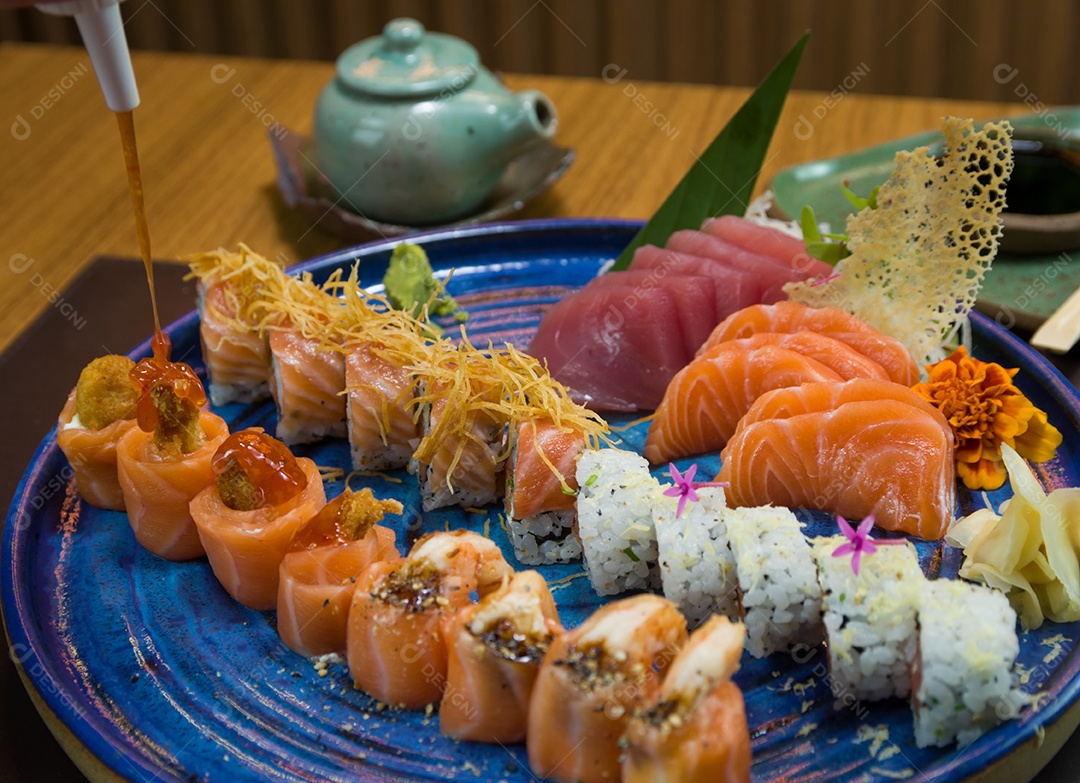 Combinado de diferentes sushis japoneses em um elegante prato azul.