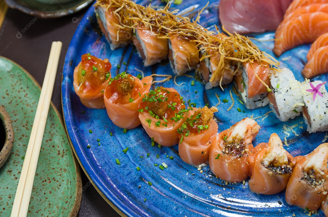 Combinado de diferentes sushis japoneses em um elegante prato azul.
