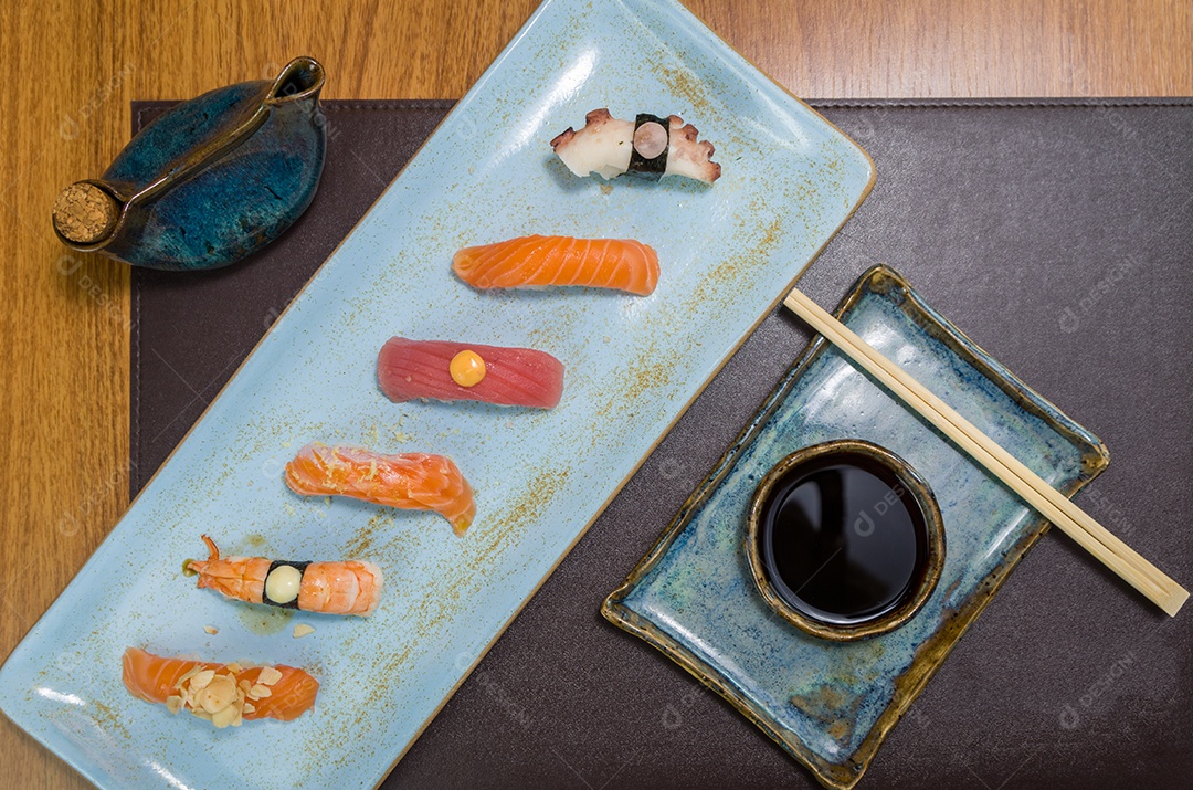 Combinado de diferentes sushis japoneses em um elegante prato azul.