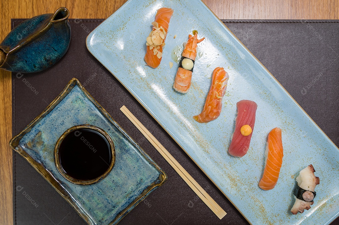 Combinado de diferentes sushis japoneses em um elegante prato azul.