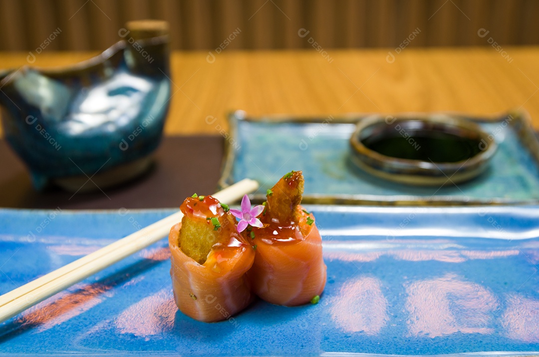 Combinado de diferentes sushis japoneses em um elegante prato azul.