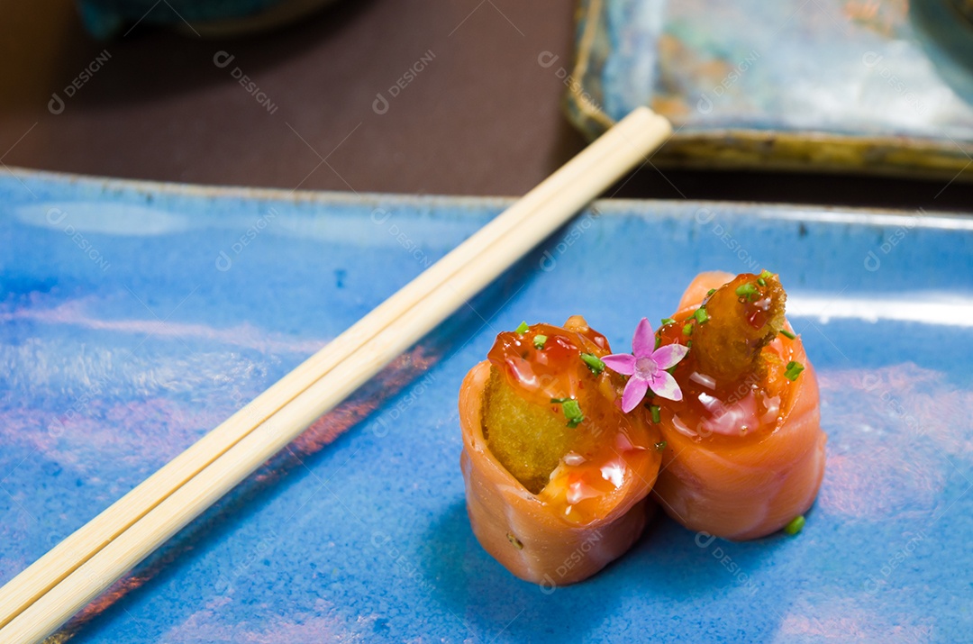 Combinado de diferentes sushis japoneses em um elegante prato azul.