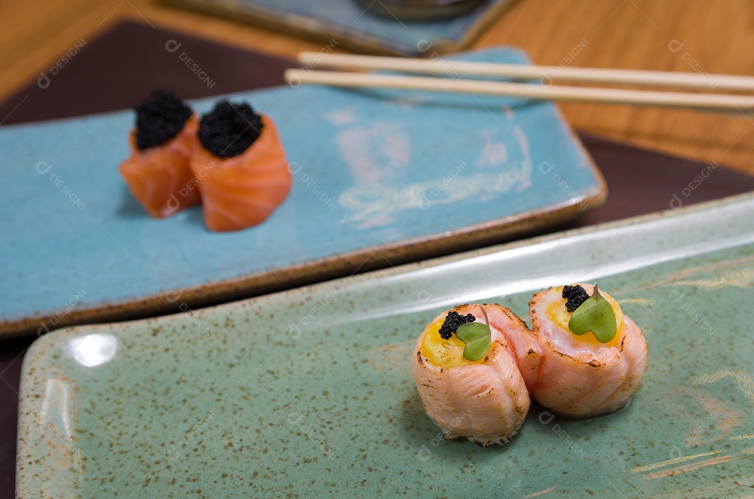Combinado de diferentes sushis japoneses em um elegante prato azul.