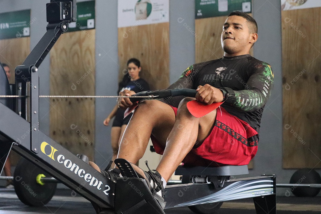 Lindo homem fazendo exercícios sobre uma academia