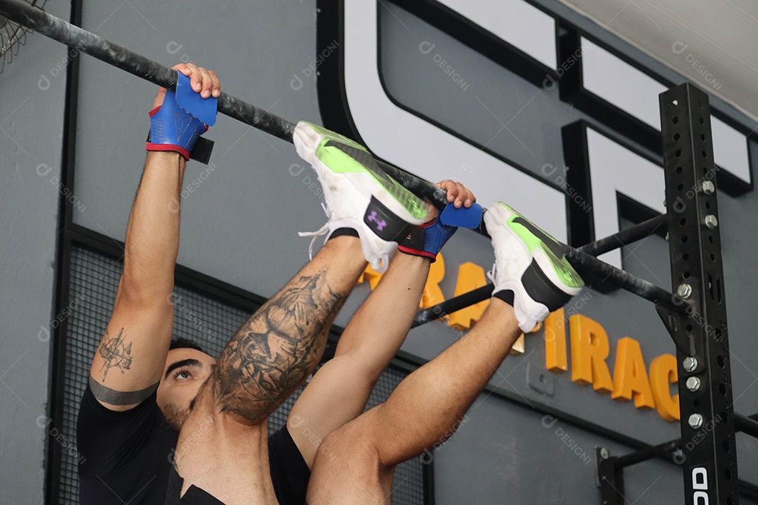 Lindo homem fazendo exercícios sobre uma academia