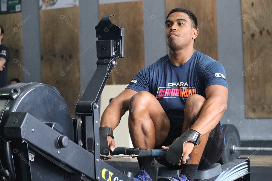 Belo homem moreno fazendo exercício sobre uma academia