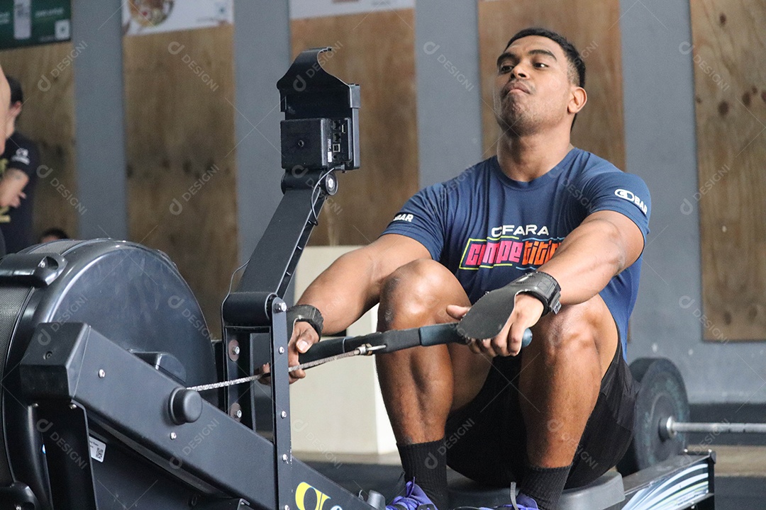 Belo homem moreno fazendo exercício sobre uma academia