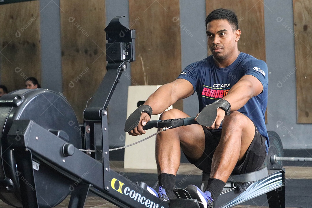 Belo homem moreno fazendo exercício sobre uma academia