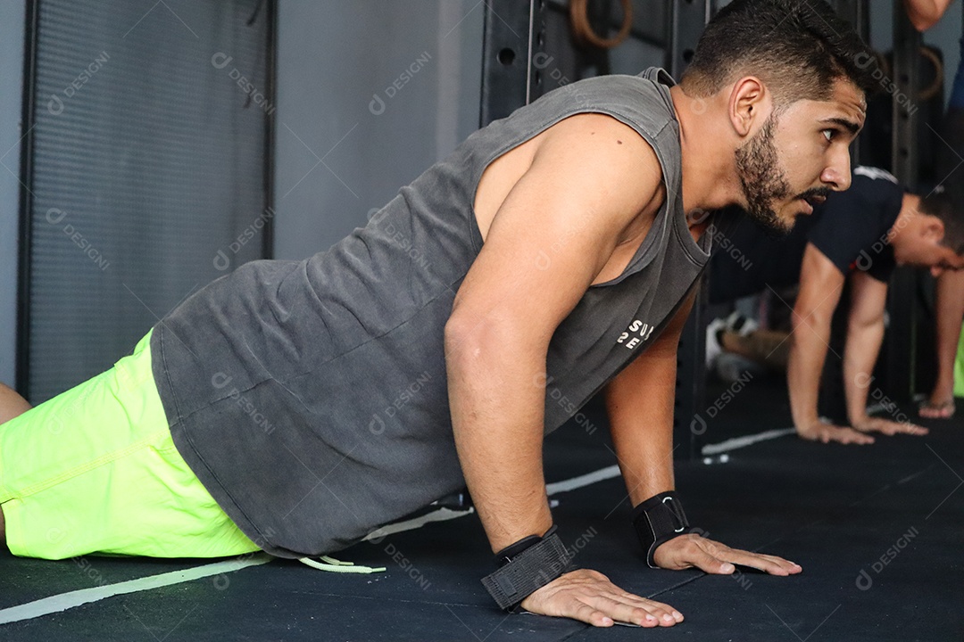Belos homens fazendo flexão sobre uma academia