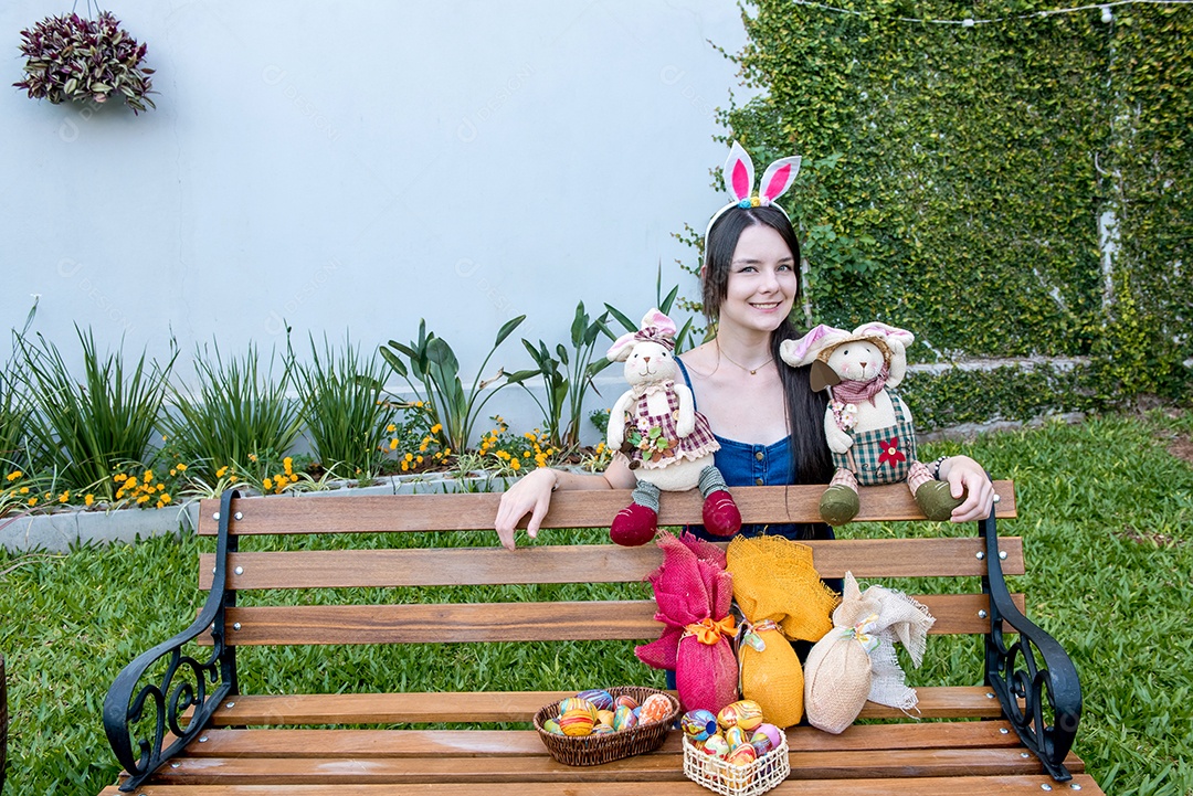 Mulher com orelhas de coelhinho da páscoa mostrando ovos de páscoa