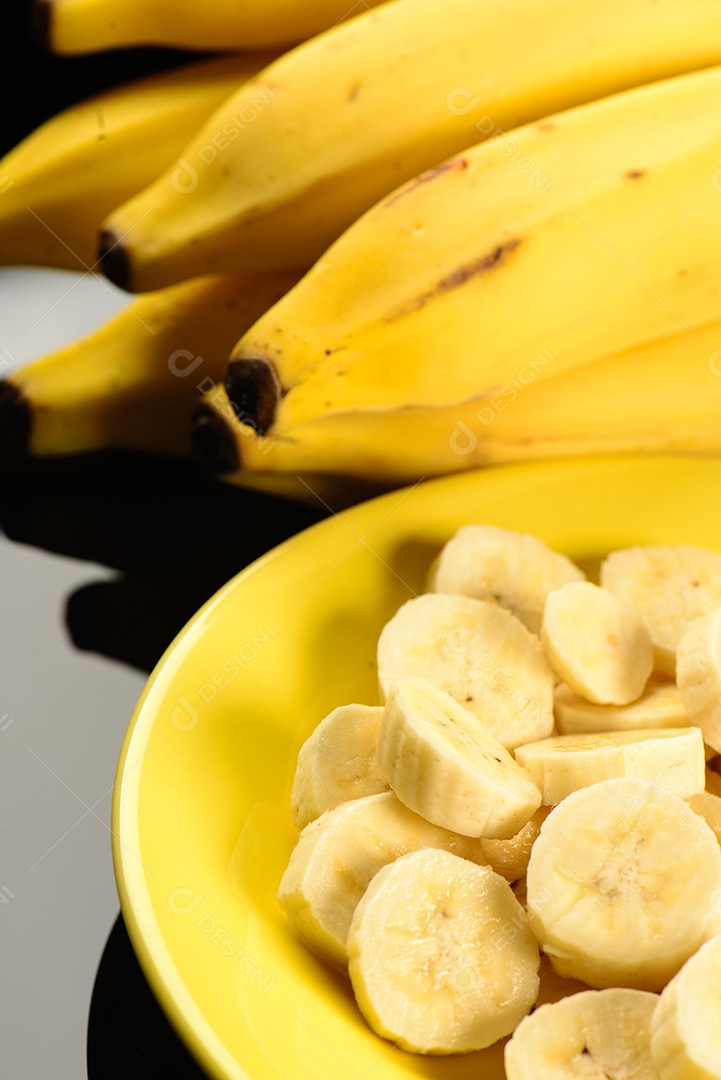 Banana inteira e fatiada na chapa amarela.