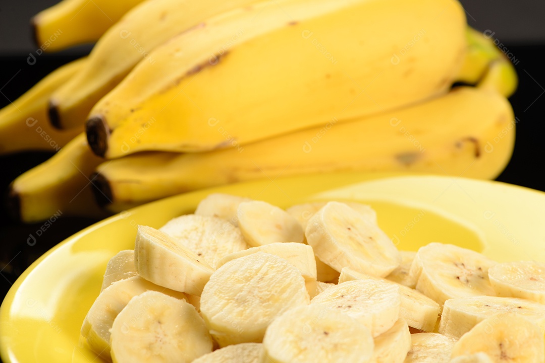 Banana inteira e fatiada na chapa amarela.