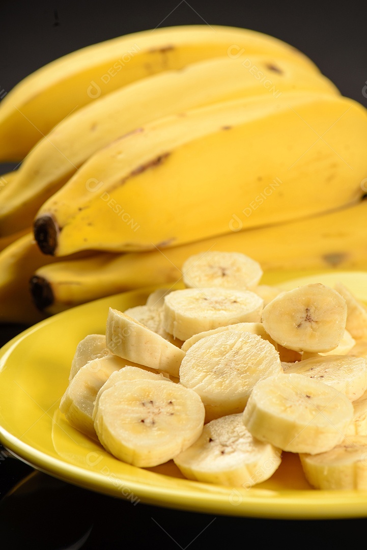Banana inteira e fatiada na chapa amarela.