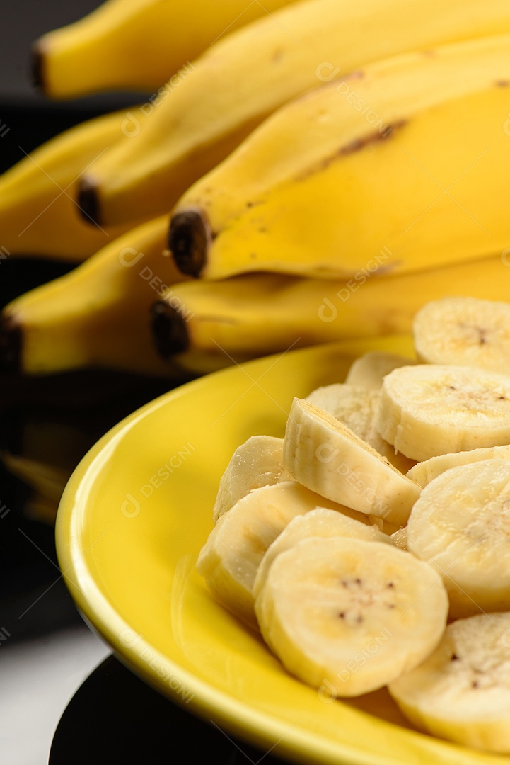 Banana inteira e fatiada na chapa amarela.