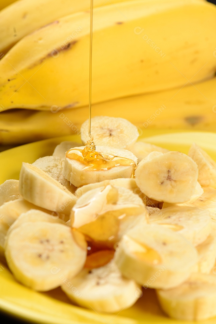 Banana inteira e fatiada na chapa amarela.