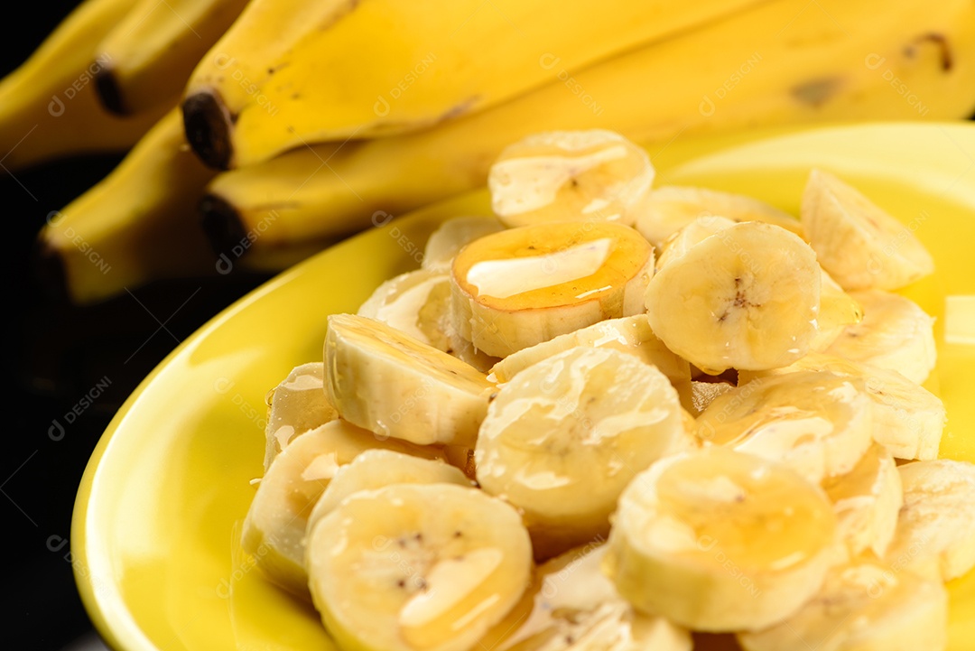 Banana inteira e fatiada na chapa amarela.