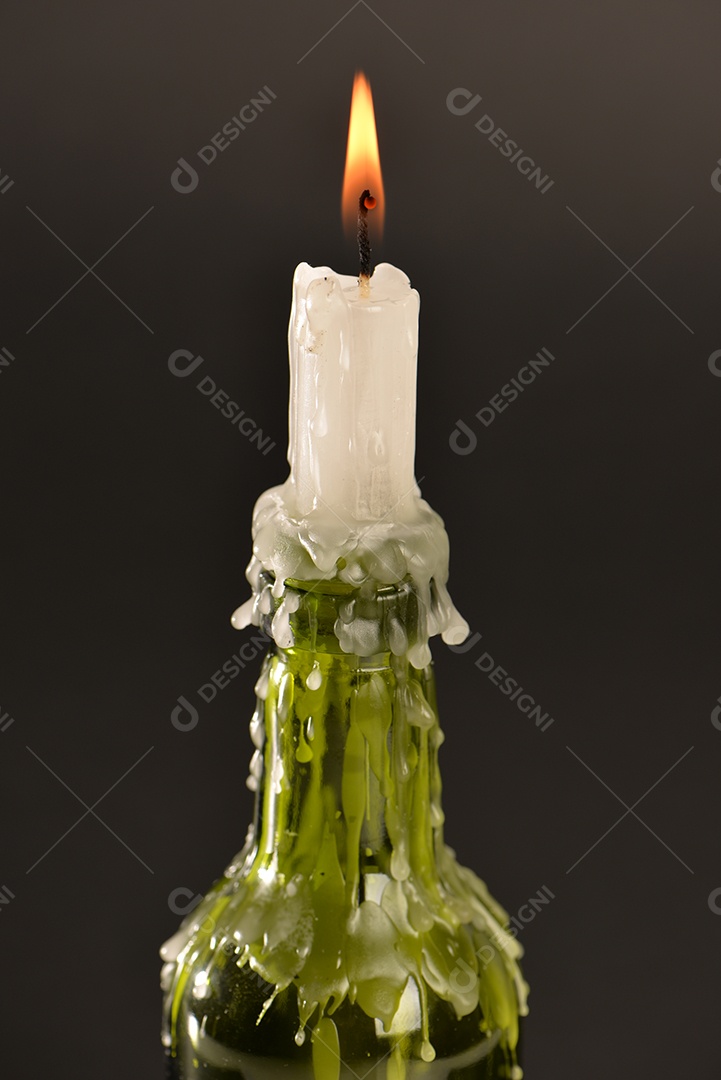 Candelabro de garrafa com vela em fundo preto.