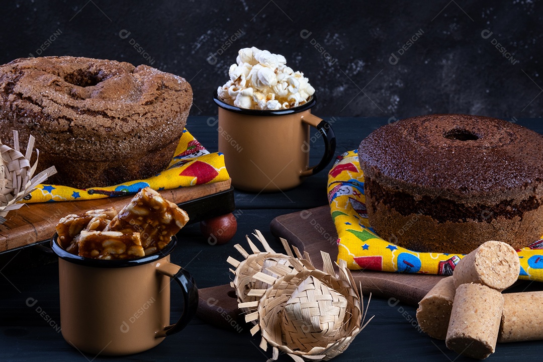 Bandeja de madeira com bolo, pipoca e docinhos de festa junina.