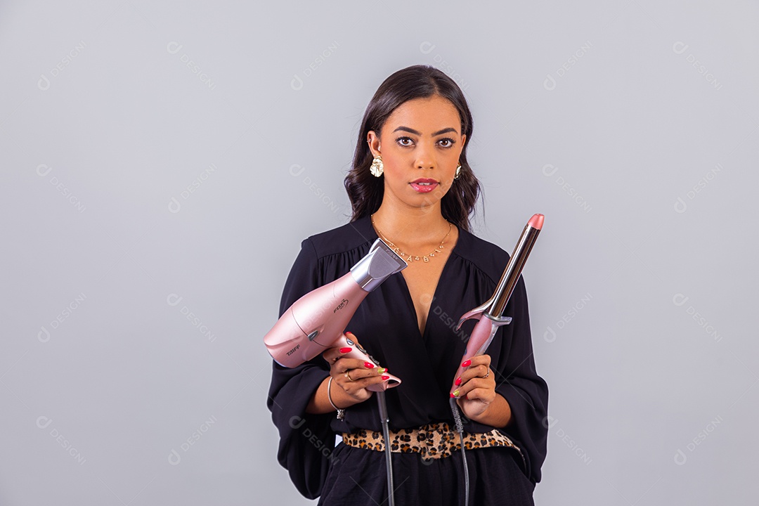 Linda mulher bonita jovem segurando escova e secador sobre fundo isolado