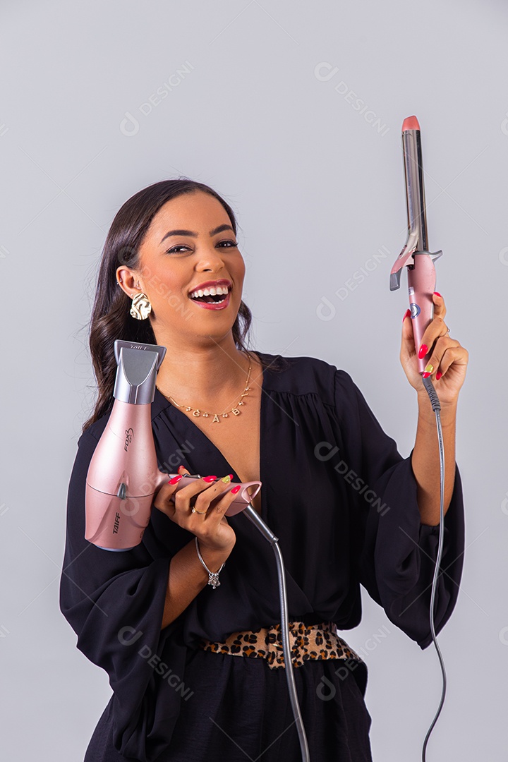 Linda mulher bonita jovem segurando escova e secador sobre fundo isolado