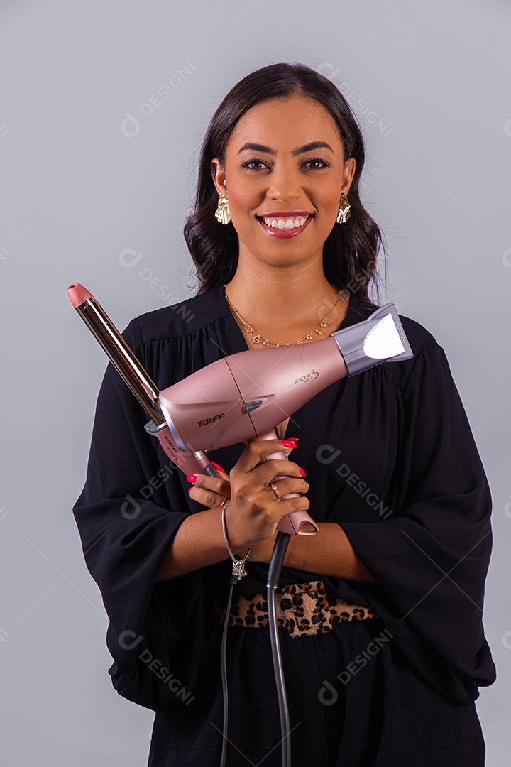 Linda mulher bonita jovem segurando escova e secador sobre fundo isolado