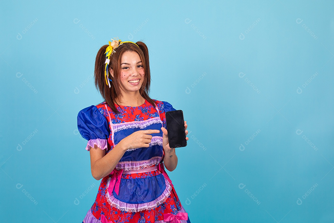 Mulher jovem fantasiada celebrando festas juninas segurando celular smartphone