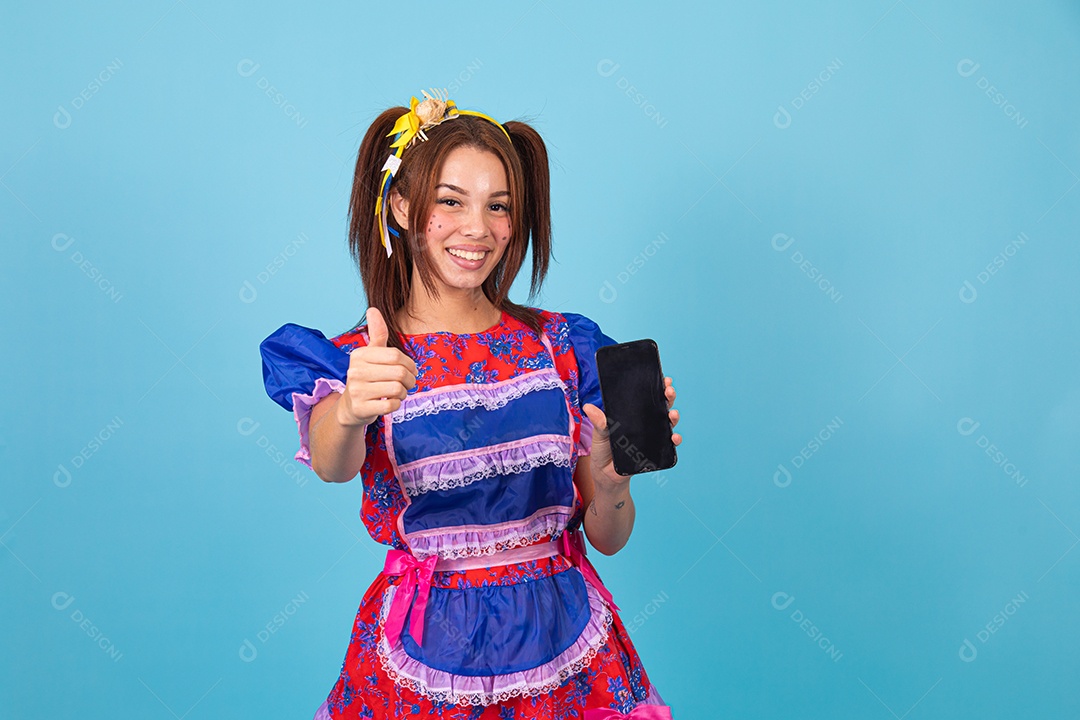 Mulher jovem fantasiada celebrando festas juninas segurando celular smartphone