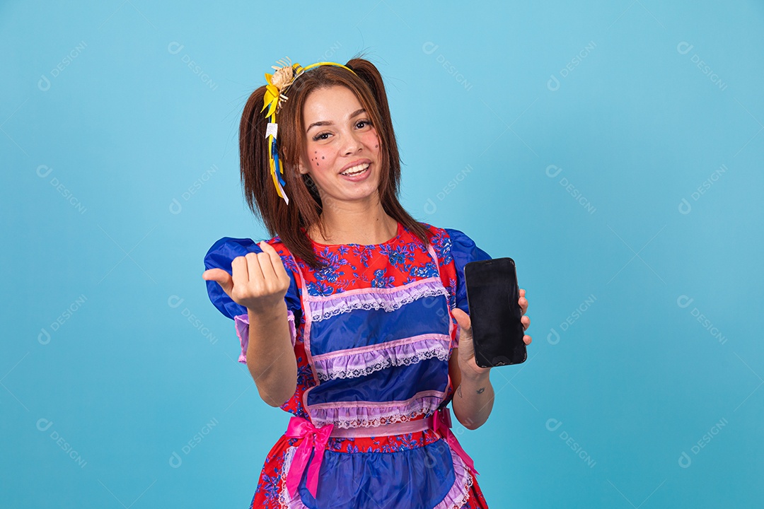 Mulher jovem fantasiada celebrando festas juninas segurando celular smartphone