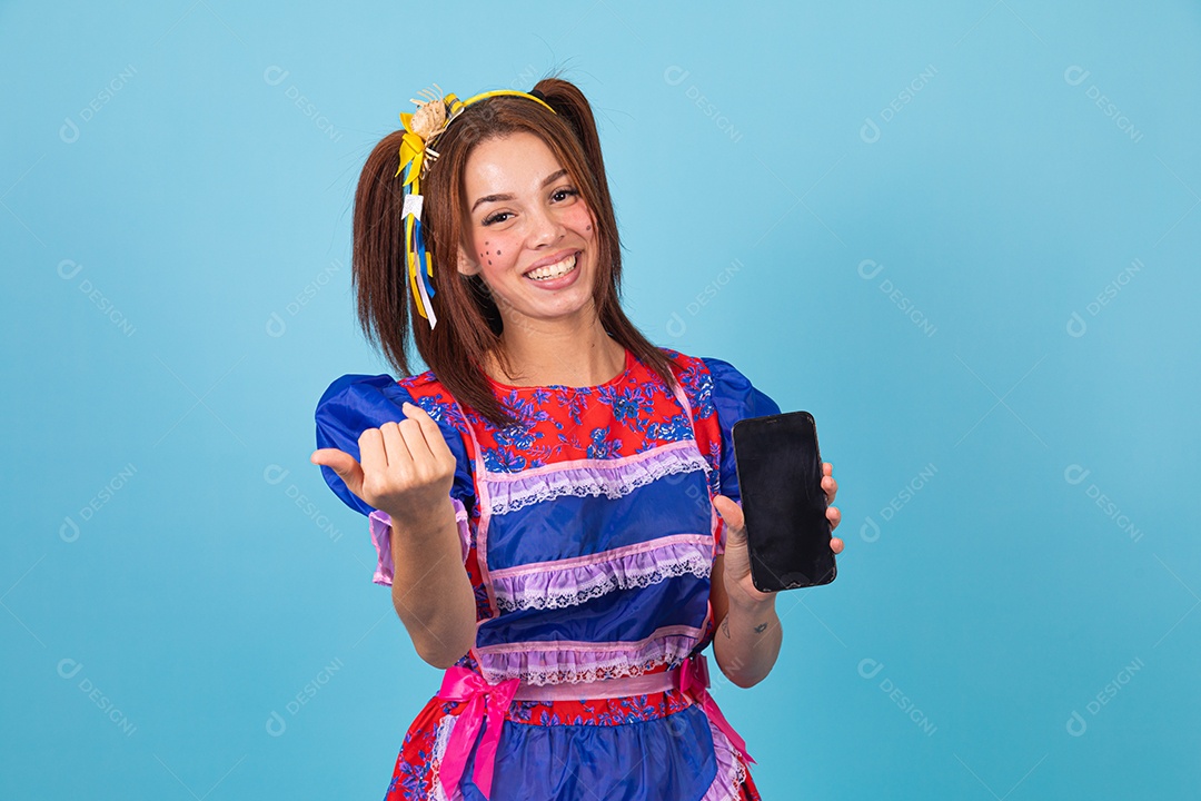 Mulher jovem fantasiada celebrando festas juninas segurando celular smartphone