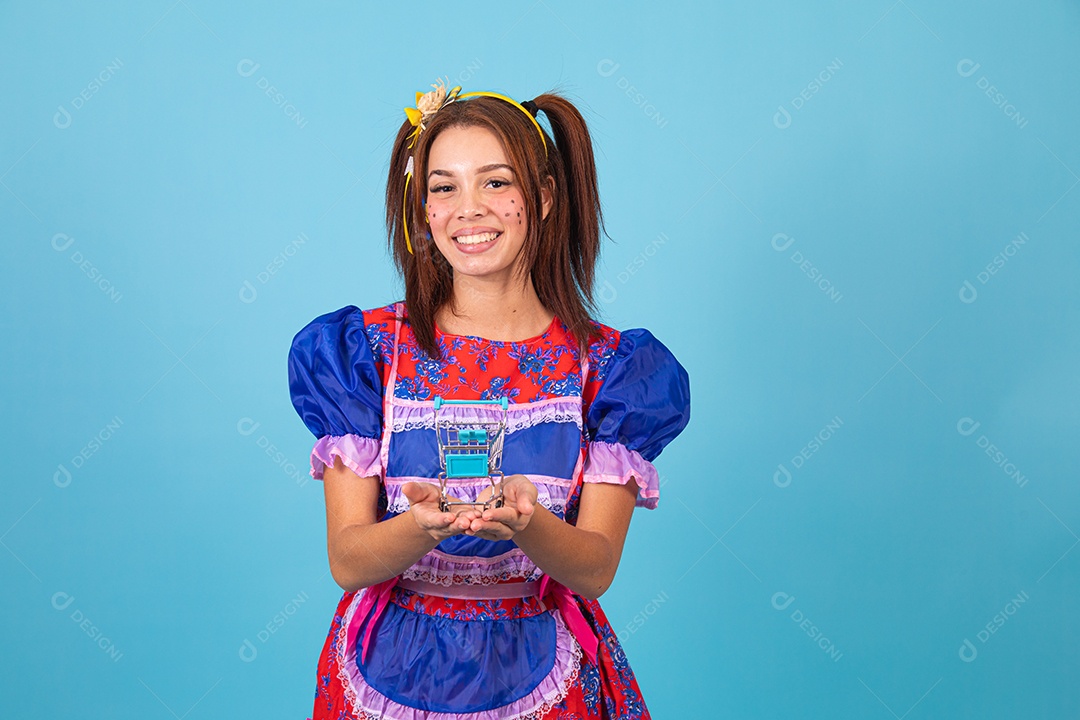 Mulher jovem fantasiada celebrando festas juninas segurando carrinho de compras de supermercado
