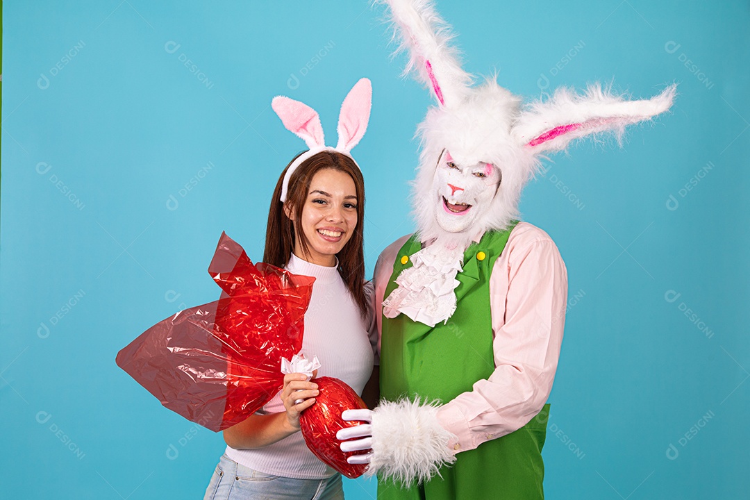 Mulher fantasiada ao lado de coelho da páscoa fantasiados
