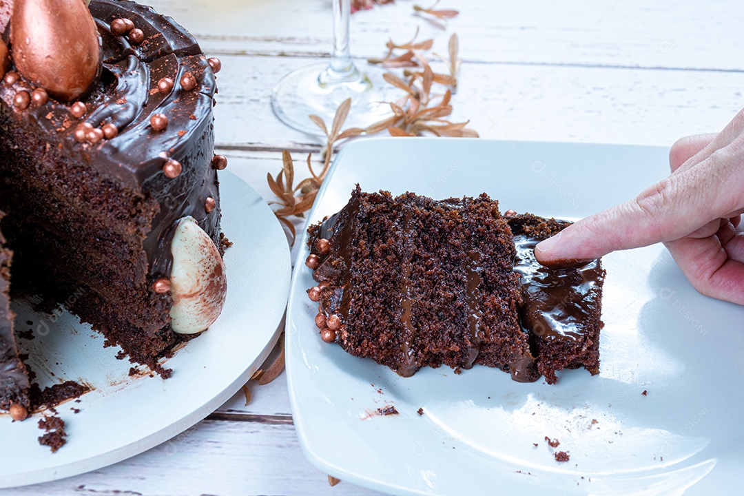 Dedo masculino tocando recheio de ganache de bolo de chocolate amargo.