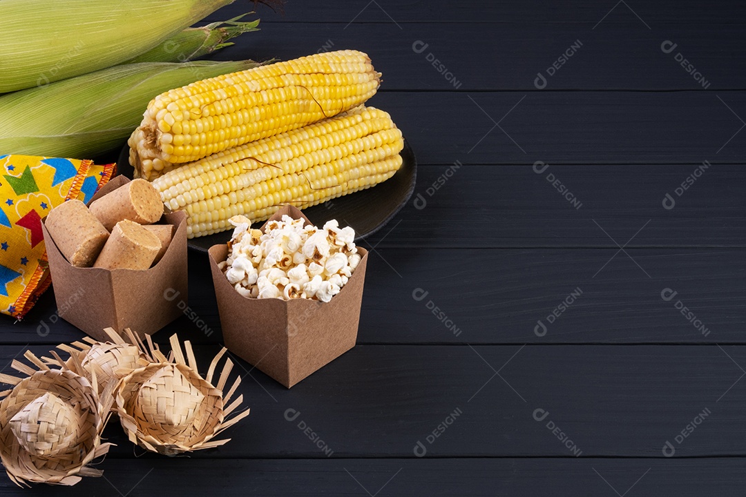 Decorações e comidas de festa junina na mesa de madeira preta