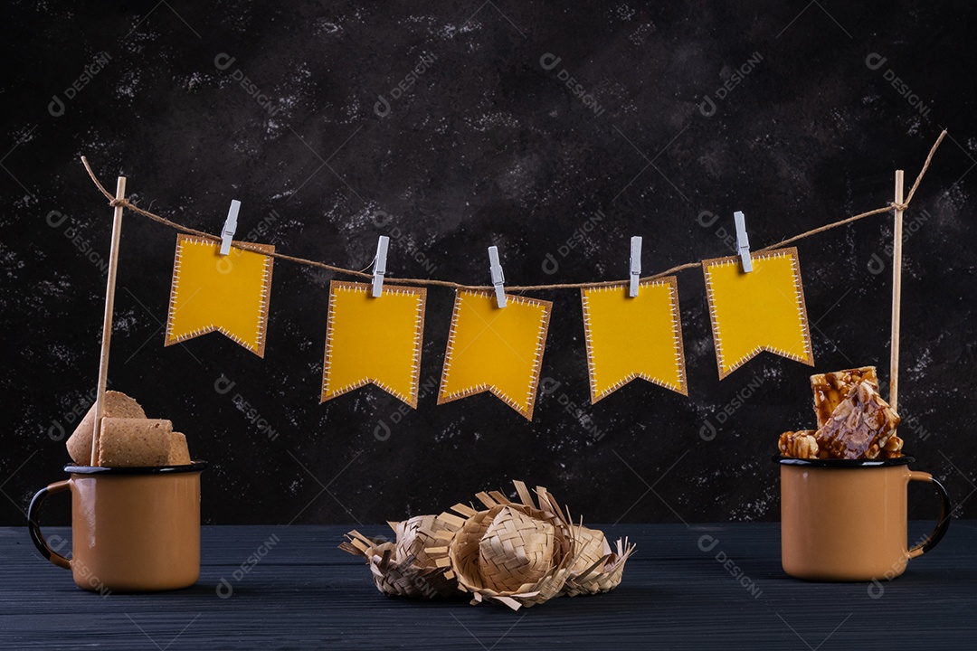 Varal feito de bandeirinhas de papel e barbante com canecas de doce