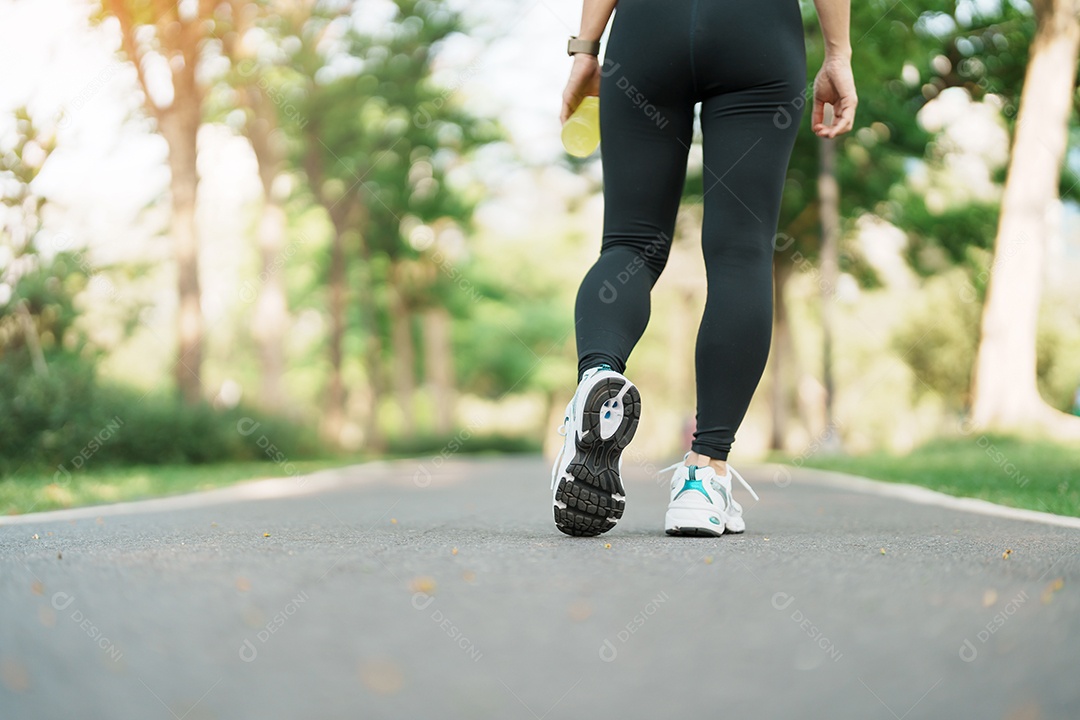Mulher correndo e andando na estrada de manhã