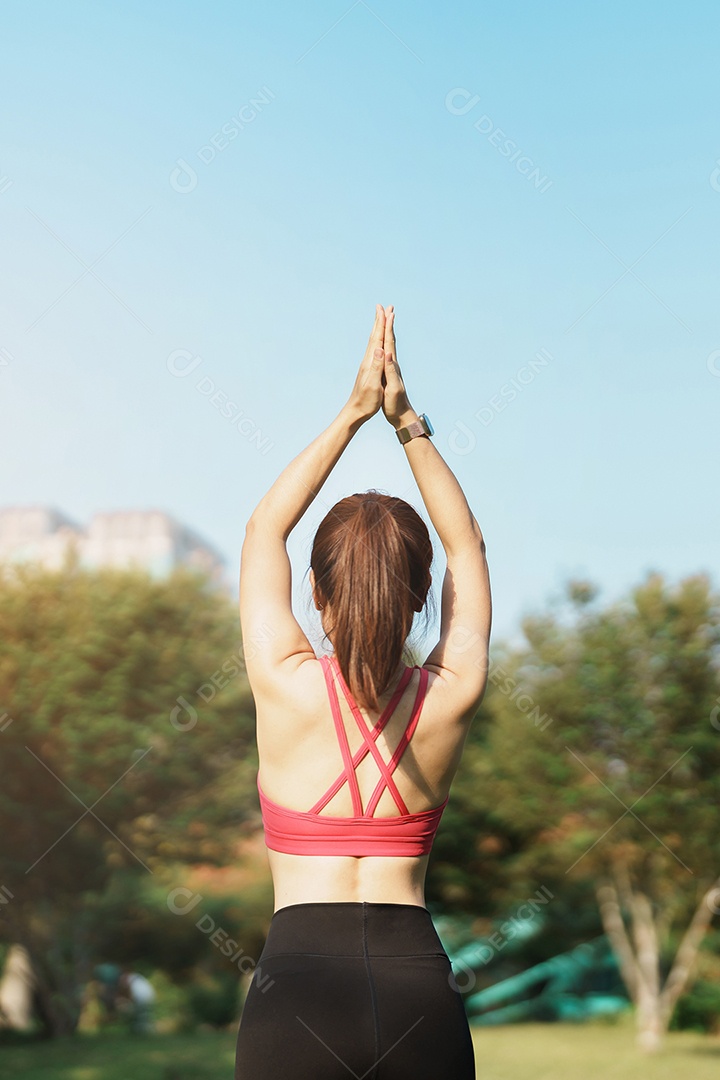 Fêmea adulta jovem em roupas esportivas fazendo Yoga no parque ao ar livre