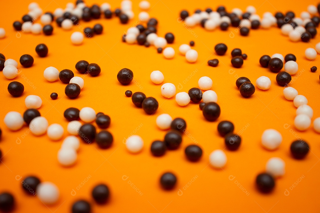 Bolas de chocolate branco e preto em um fundo laranja