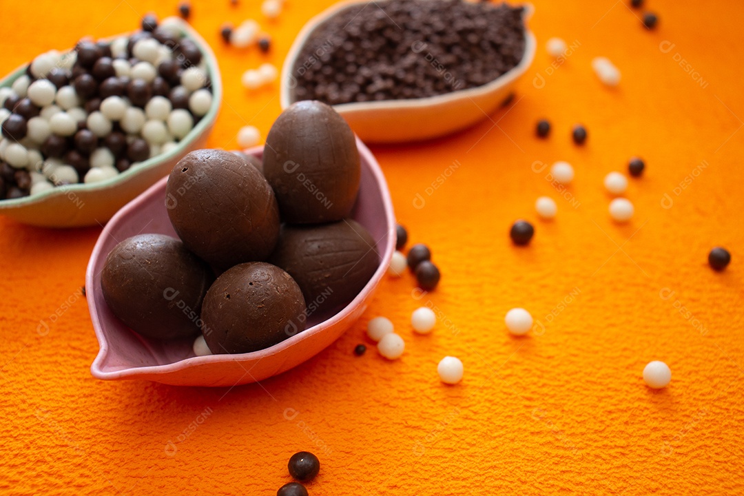 Cestas de bolas de chocolate em um fundo laranja