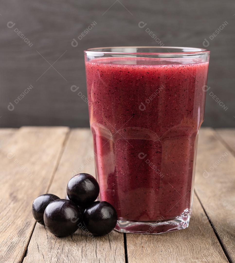 Suco de jabuticaba com frutas sobre mesa de madeira