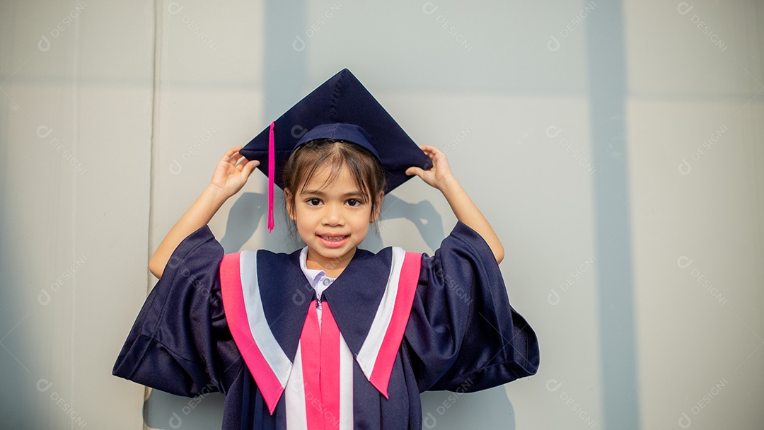 Meninas asiáticas felizes em vestidos de formatura no dia da formatura na escola.