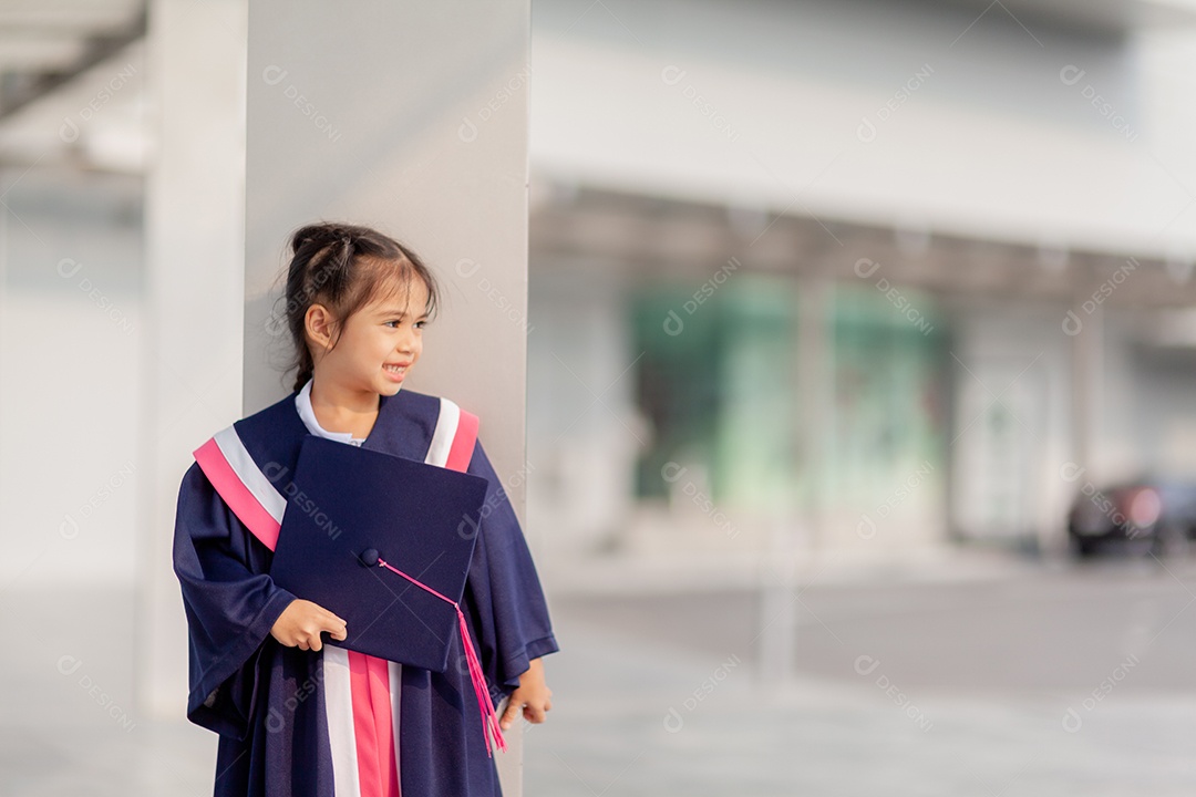 Meninas asiáticas felizes em vestidos de formatura no dia da formatura na escola.