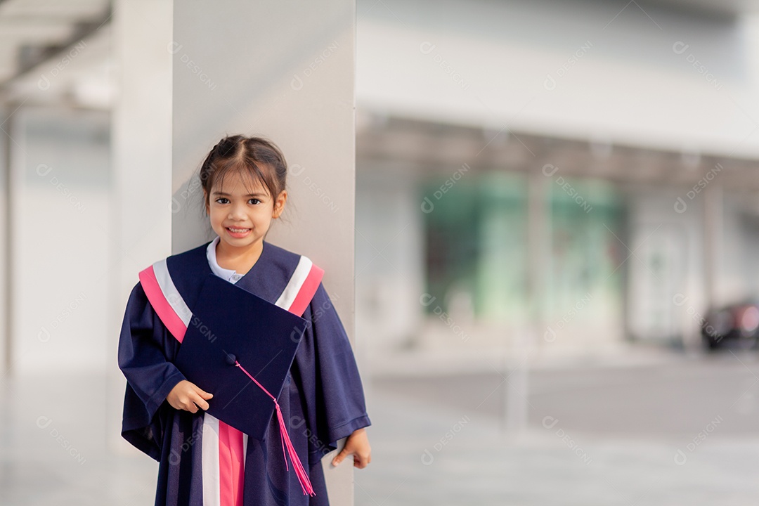 Meninas asiáticas felizes em vestidos de formatura no dia da formatura na escola.