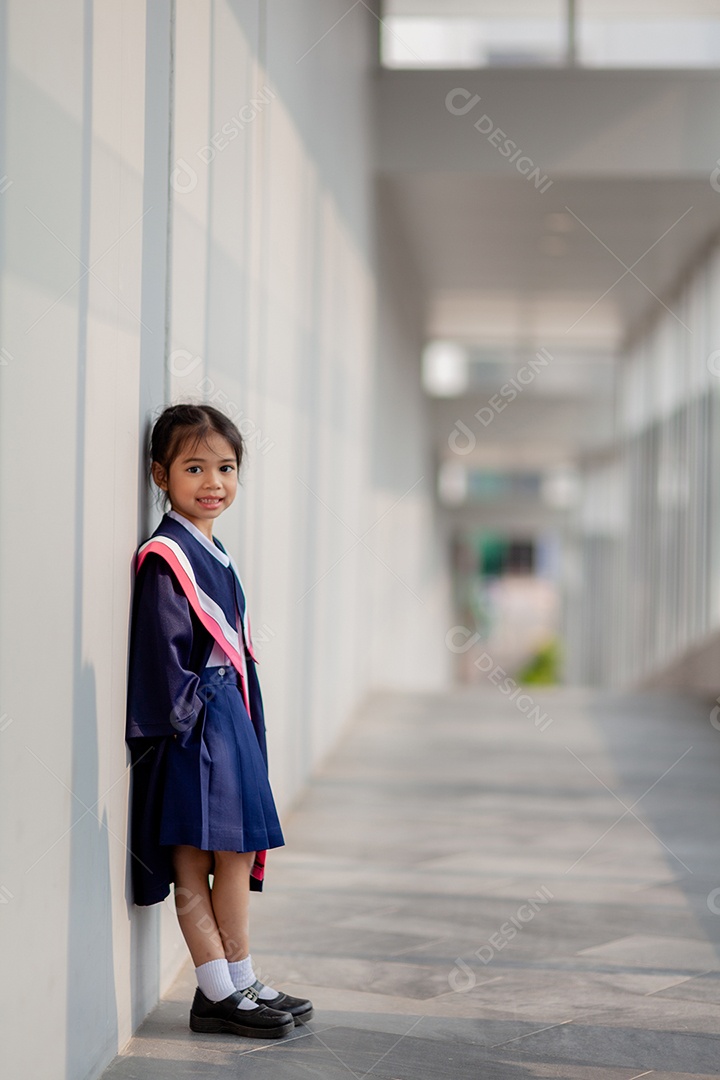 Meninas asiáticas felizes em vestidos de formatura no dia da formatura na escola.