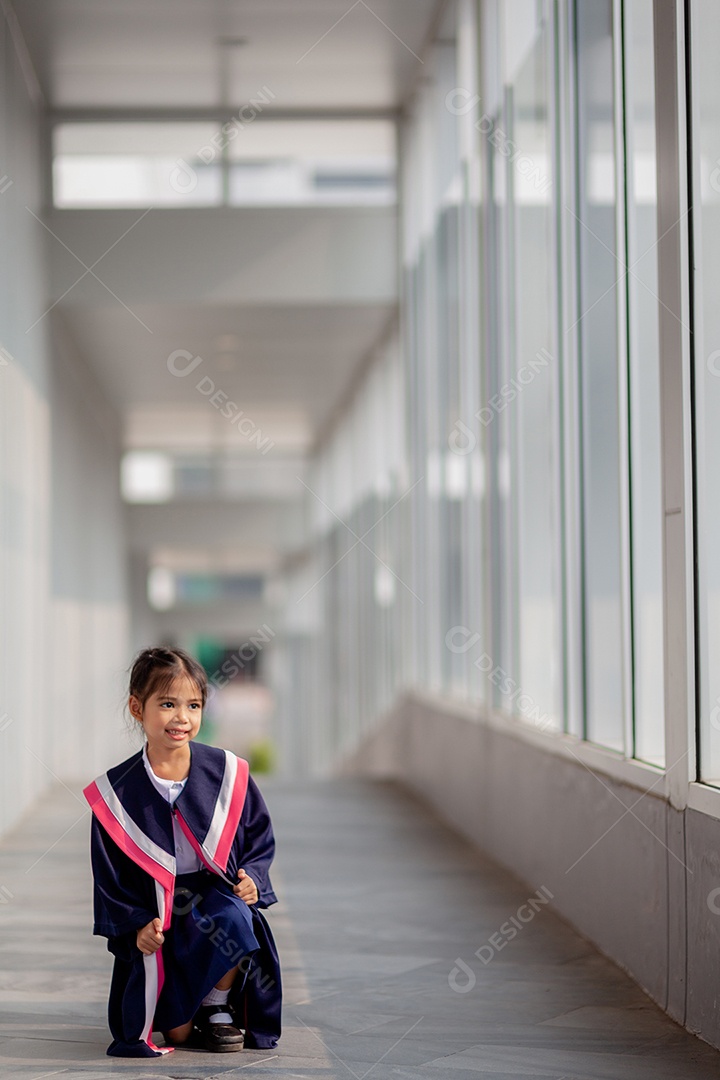 Meninas asiáticas felizes em vestidos de formatura no dia da formatura na escola.
