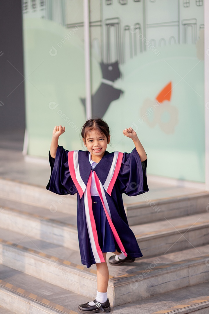 Meninas asiáticas felizes em vestidos de formatura no dia da formatura na escola.