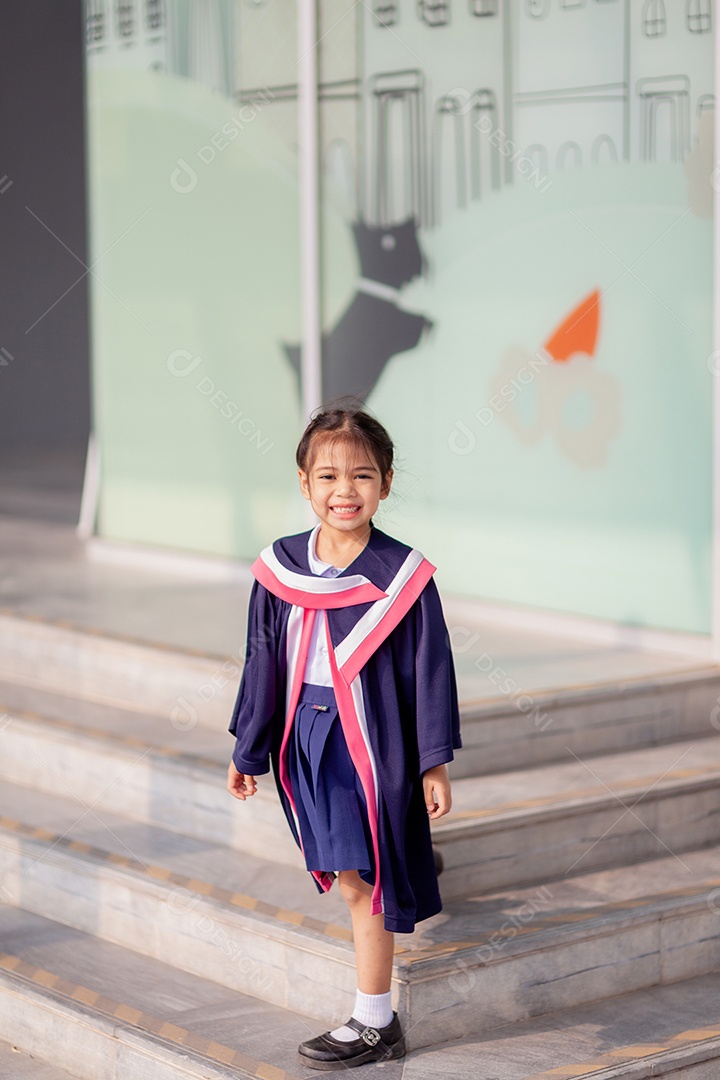 Meninas asiáticas felizes em vestidos de formatura no dia da formatura na escola.