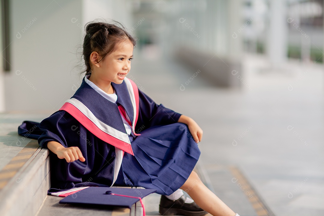 Meninas asiáticas felizes em vestidos de formatura no dia da formatura na escola.