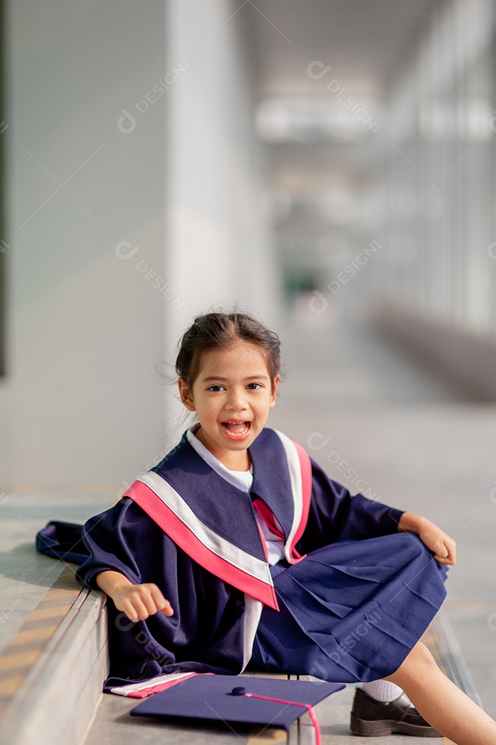 Meninas asiáticas felizes em vestidos de formatura no dia da formatura na escola.