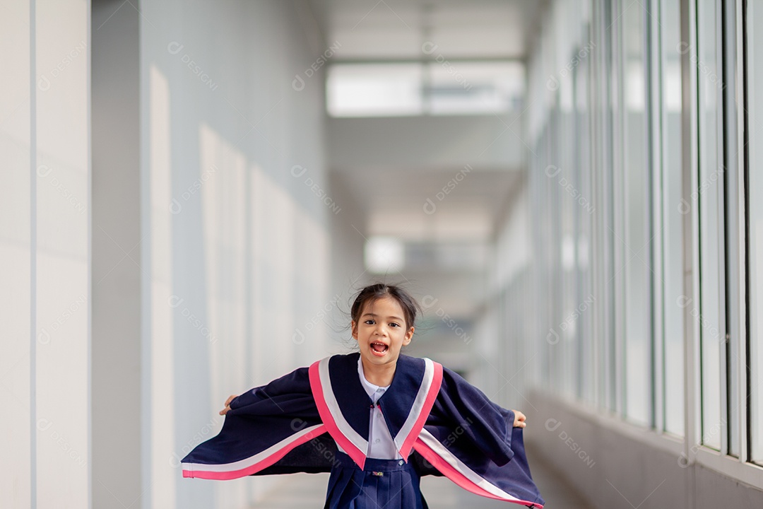 Meninas asiáticas felizes em vestidos de formatura no dia da formatura na escola.