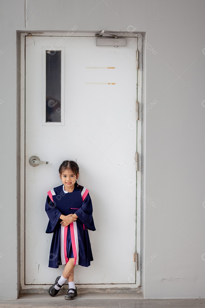 Meninas asiáticas felizes em vestidos de formatura no dia da formatura na escola.